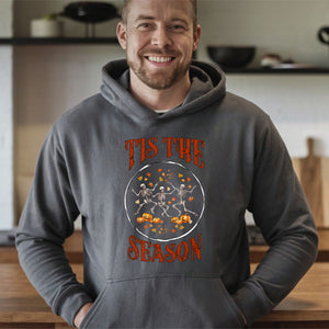 A man wearing a grey hoodie with a graphic design on it, smiling at the camera.
