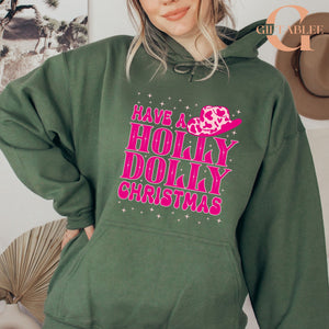 A woman wearing a green hoodie with a pink and white design that says "HAVE A HOLY DOLLY CHRISTMAS" printed on it.