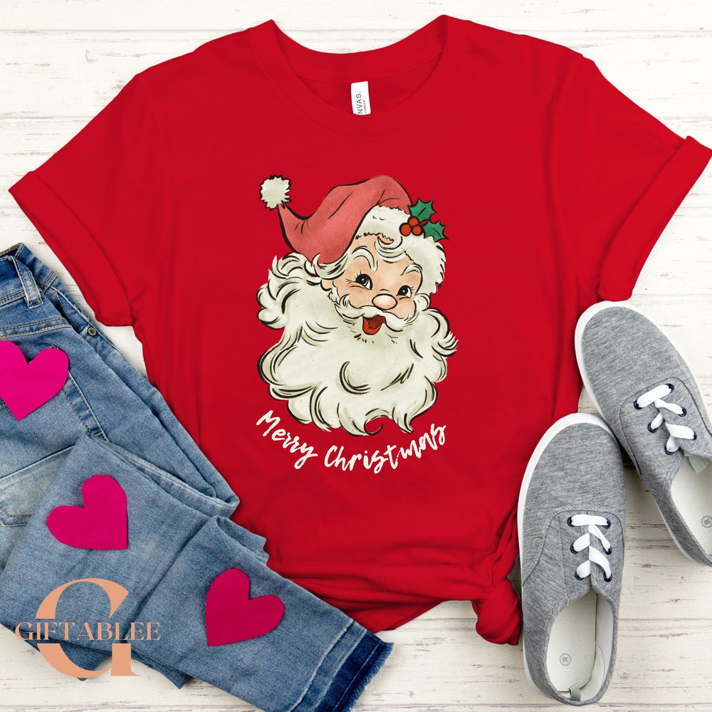 A red t-shirt with a Santa Claus graphic and the text "Merry Christmas" printed on it, along with a pair of jeans and gray sneakers.