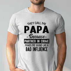 A man wearing a gray t-shirt with a humorous text printed on it.