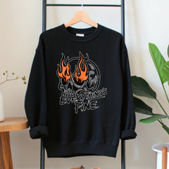 A black sweatshirt with a graphic design featuring a skull with flames and the text "EVERYTHING'S FINE" printed on it.