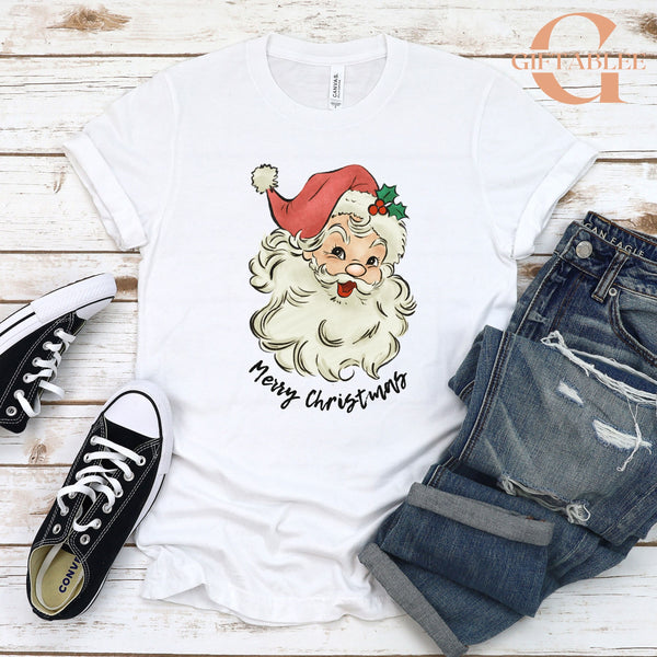 A white t-shirt with a Santa Claus graphic and the text "Merry Christmas" printed on it, along with a pair of jeans and black and white sneakers.