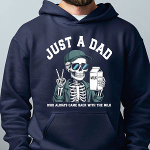 A person wearing a navy blue hoodie with a graphic design depicting a skeleton wearing sunglasses and holding a carton of milk, along with the text "Just a Dad" and "Who always came back with the milk".