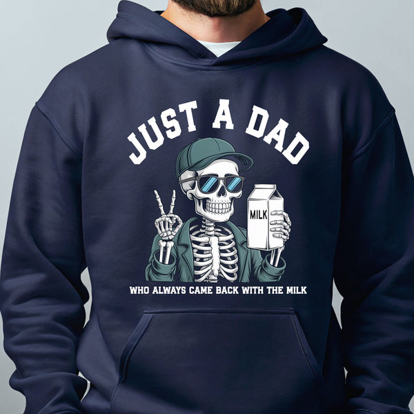 A person wearing a navy blue hoodie with a graphic design depicting a skeleton wearing sunglasses and holding a carton of milk, along with the text "Just a Dad" and "Who always came back with the milk".
