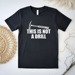 a black t-shirt with a humorous text printed on it, which reads "THIS IS NOT A DRILL".