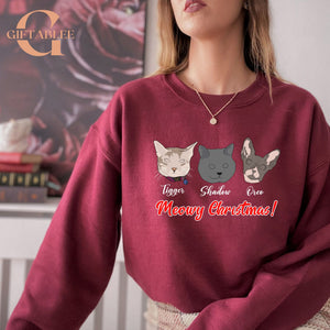 A woman wearing a red sweater with a graphic design featuring three cat faces and the text "Meowy Christmas!"