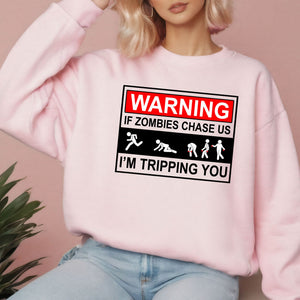 A woman wearing a pink sweatshirt with a warning graphic printed on it.