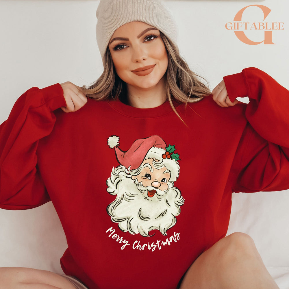 A woman wearing a red sweater with a Santa Claus design and the text "Merry Christmas" is posing for a photo.