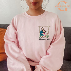 A woman wearing a pink sweater with a graphic design on the front.