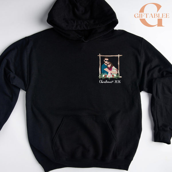 A black hoodie with a graphic design on the front, depicting a couple in a frame. The text "Christmas 2006" is printed below the image.