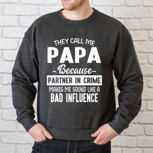A man wearing a gray sweatshirt with white text printed on it.