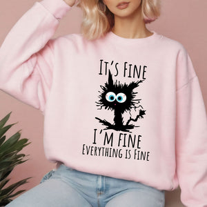 A woman wearing a pink sweatshirt with a graphic design of a cat with a message that reads "It's fine I'm fine everything is fine".