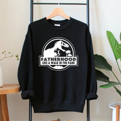 A black sweatshirt with a graphic design and text printed on it, hanging on a wooden hanger.