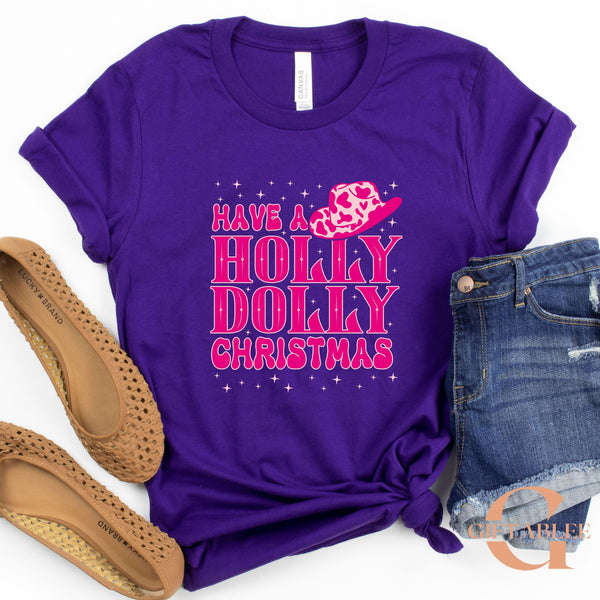 A purple t-shirt with a pink and white design, a pair of brown flat shoes, and a pair of blue denim shorts are arranged on a white background.