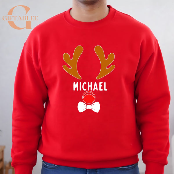 A red sweater with a graphic design featuring a pair of antlers and the name "MICHAEL" printed on it.