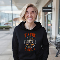 A smiling woman wearing a black hoodie with a Halloween-themed graphic and text.