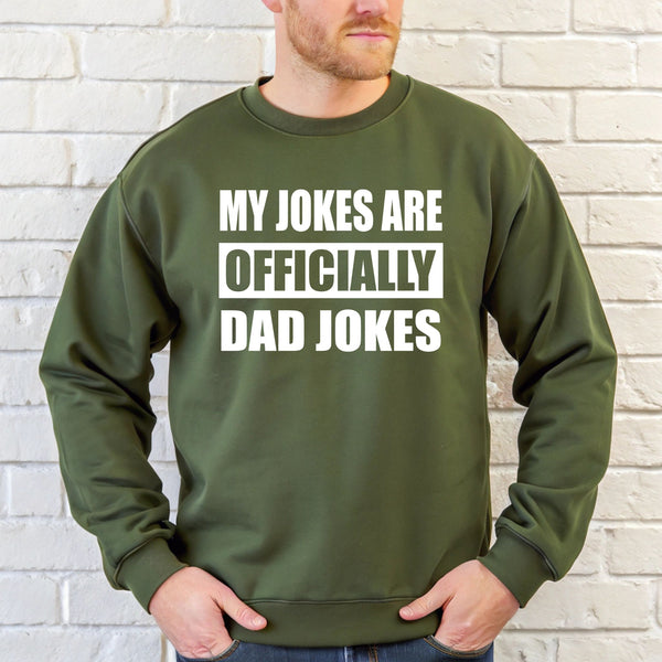 A man wearing a green sweatshirt with the text "MY JOKES ARE OFFICIALLY DAD JOKES" printed on it.