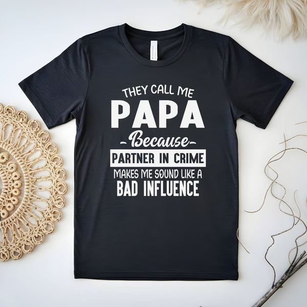 A black t-shirt with white text that reads "They call me papa because partner in crime makes me sound like a bad influence".