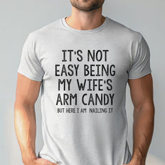 A man wearing a gray t-shirt with a humorous text printed on it.