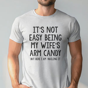A man wearing a gray t-shirt with a humorous text printed on it.