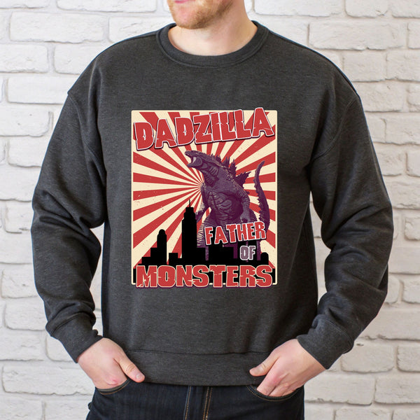 A man wearing a gray sweatshirt with a graphic design featuring a large Godzilla-like creature and the text "DADZILLA FATHER OF MONSTERS" printed on it.