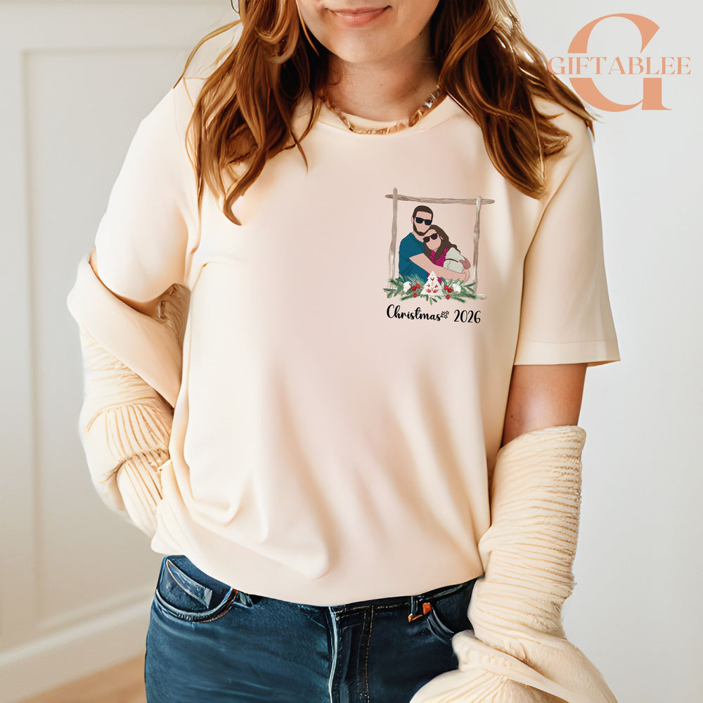 A woman wearing a white t-shirt with a graphic design of a couple embracing, and a sweater draped over her shoulders.