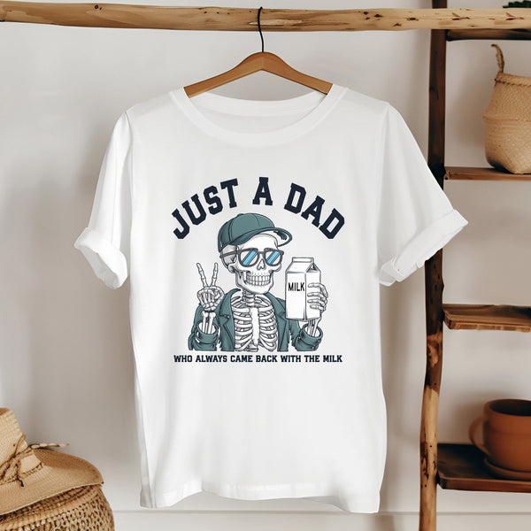 A white t-shirt with a graphic design depicting a skeleton wearing sunglasses and holding a carton of milk, along with the text "Just a Dad" and "Who always came back with the milk".