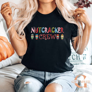 A woman wearing a black t-shirt with the text "Nutcracker Crew" printed on it, sitting on a couch.