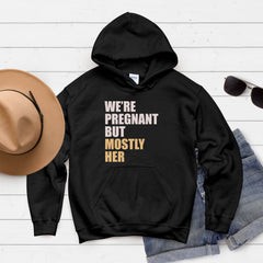 A black hoodie with text printed on it, along with a hat, sunglasses, and some clothing items, all laid out on a white background.