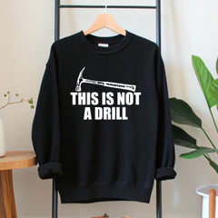 A black sweatshirt with a humorous text printed on it, hanging on a wooden hanger.