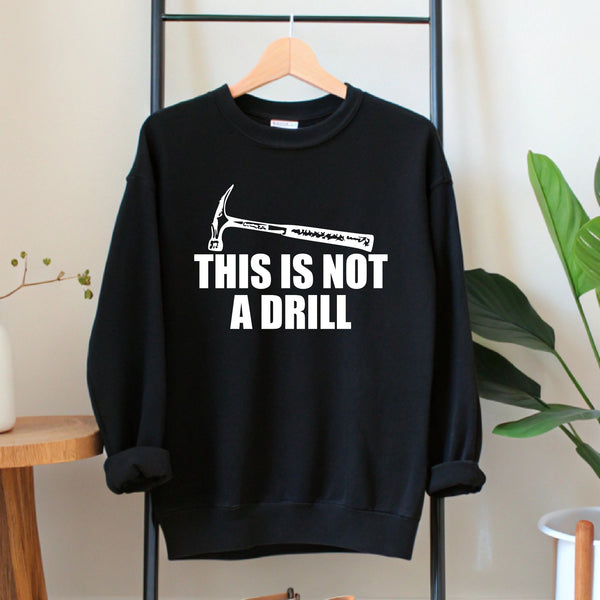 A black sweatshirt with a humorous text printed on it, hanging on a wooden hanger.
