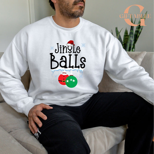 A man wearing a white sweatshirt with a humorous text and graphics printed on it, sitting on a couch.