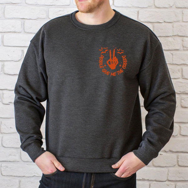 A man wearing a grey sweatshirt with an orange graphic on the front.
