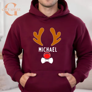 A man wearing a burgundy hoodie with a graphic design featuring a reindeer and the name "MICHAEL" printed on it.
