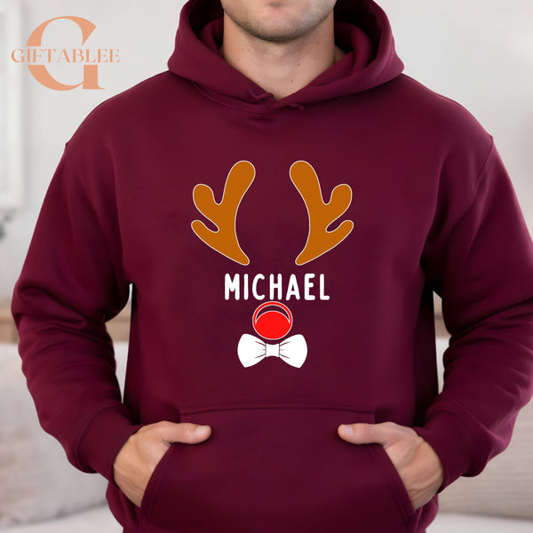A man wearing a burgundy hoodie with a graphic design featuring a reindeer and the name "MICHAEL" printed on it.