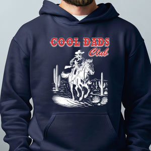 A navy blue hoodie with a graphic design depicting a cowboy riding a horse in a desert landscape, with the text "Cool Dads Club" above the image.