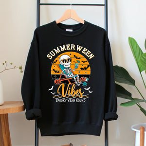 A black sweatshirt with a Halloween-themed graphic design hanging on a wooden hanger.
