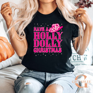 A woman wearing a black t-shirt with a pink and white design and text, sitting on a couch.